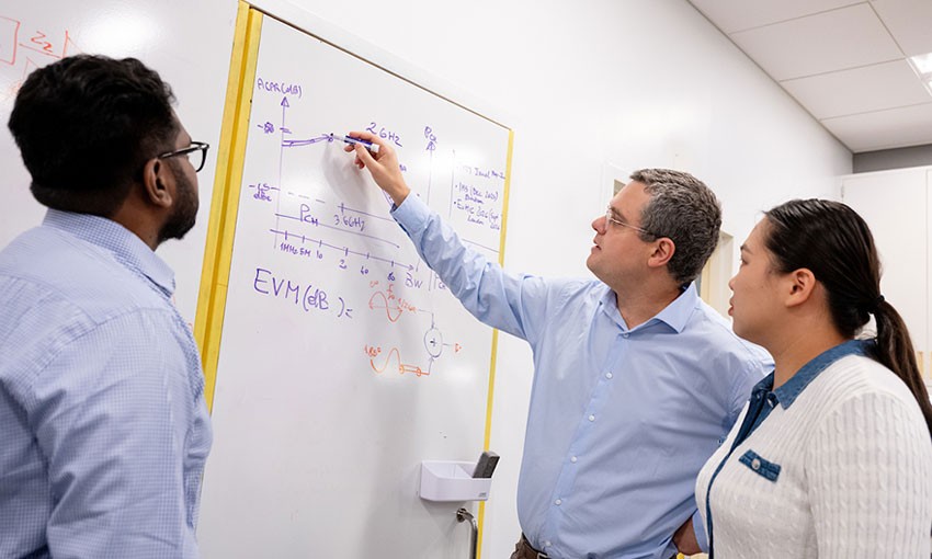 engineering-professor-students-whiteboard Professor and students standing in front of whiteboard